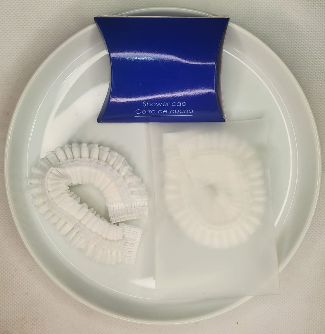 Gorros de ducha para hotel en empaque azul individual.
